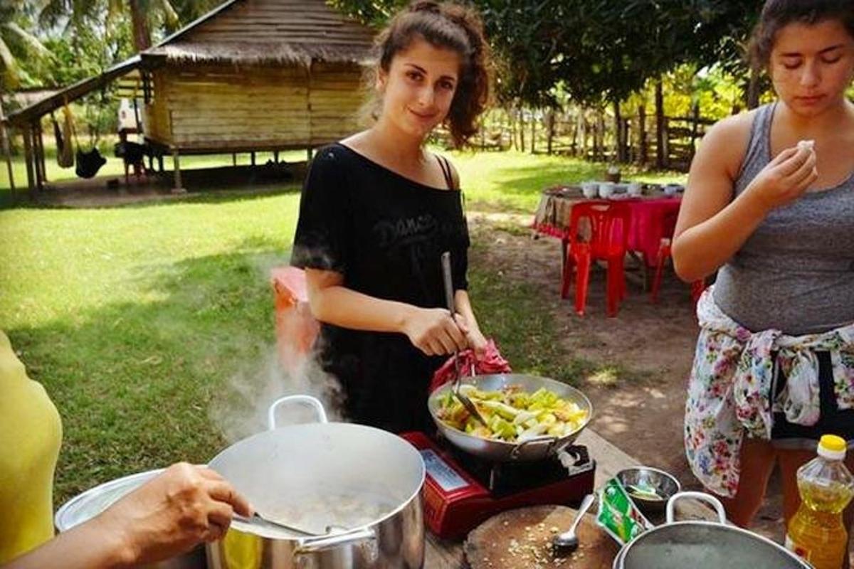una donna che cucina il cibo in una padella su una griglia