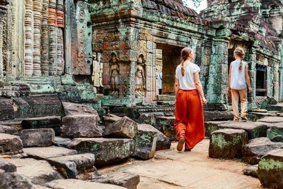 hai người phụ nữ đang đi bộ xung quanh một tòa nhà có đá