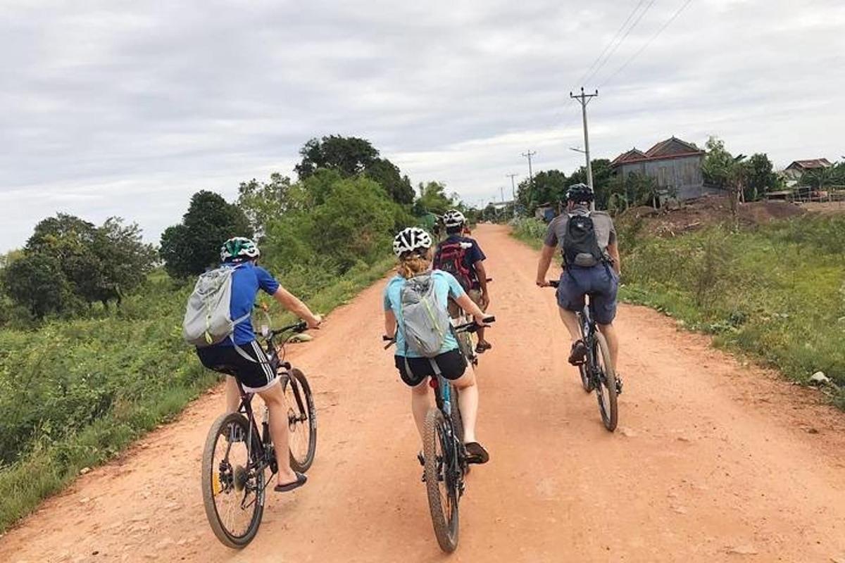 skupina ľudí jazdiacich na bicykloch po prašnej ceste
