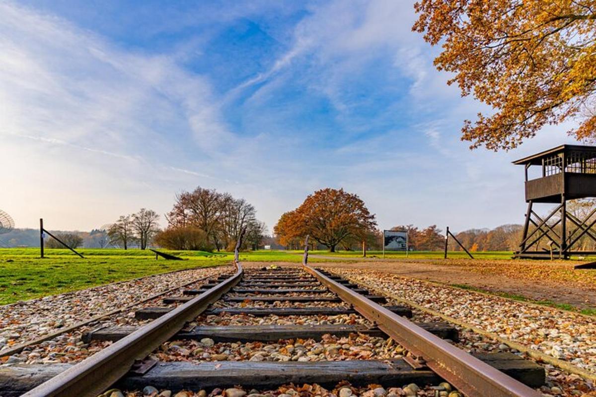 una via de tren buida en un camp amb una torre