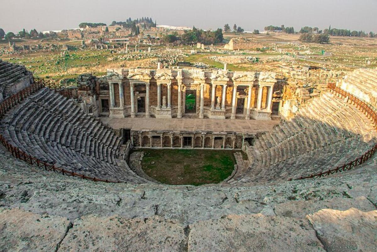 un anfiteatro vuoto con una città sullo sfondo