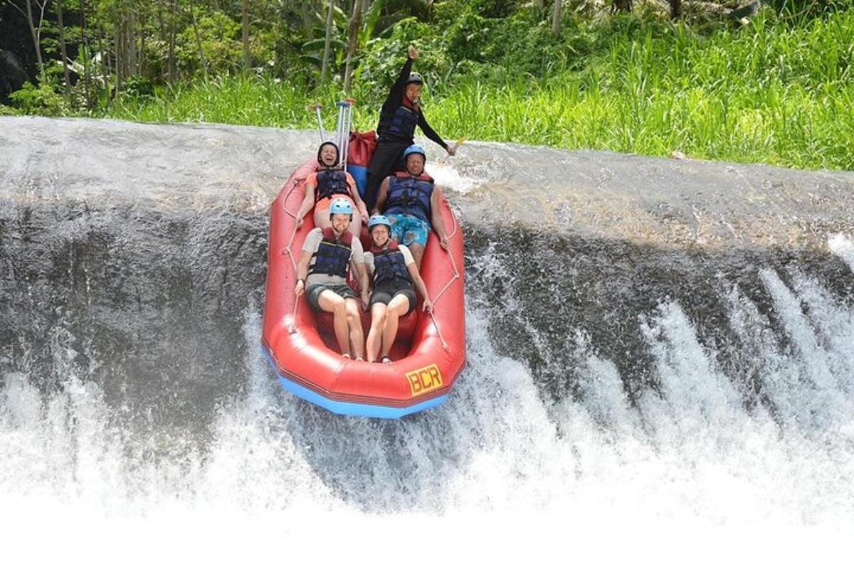 een groep mensen die op een vlot op een waterval rijden
