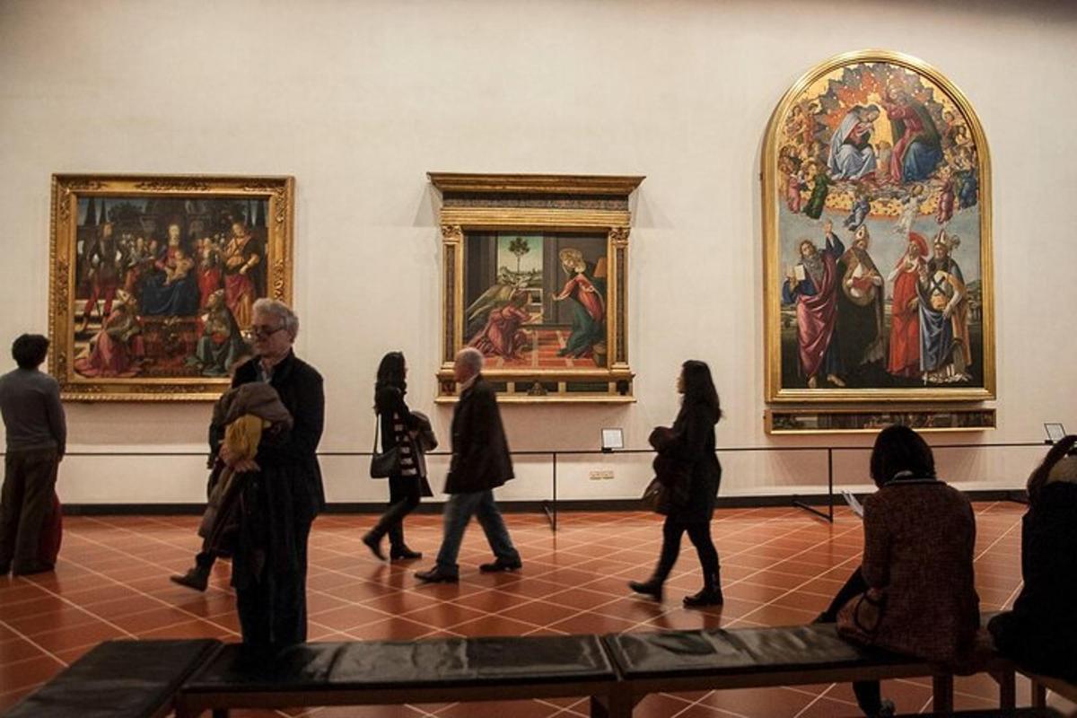un gruppo di persone che camminano in un museo con dipinti