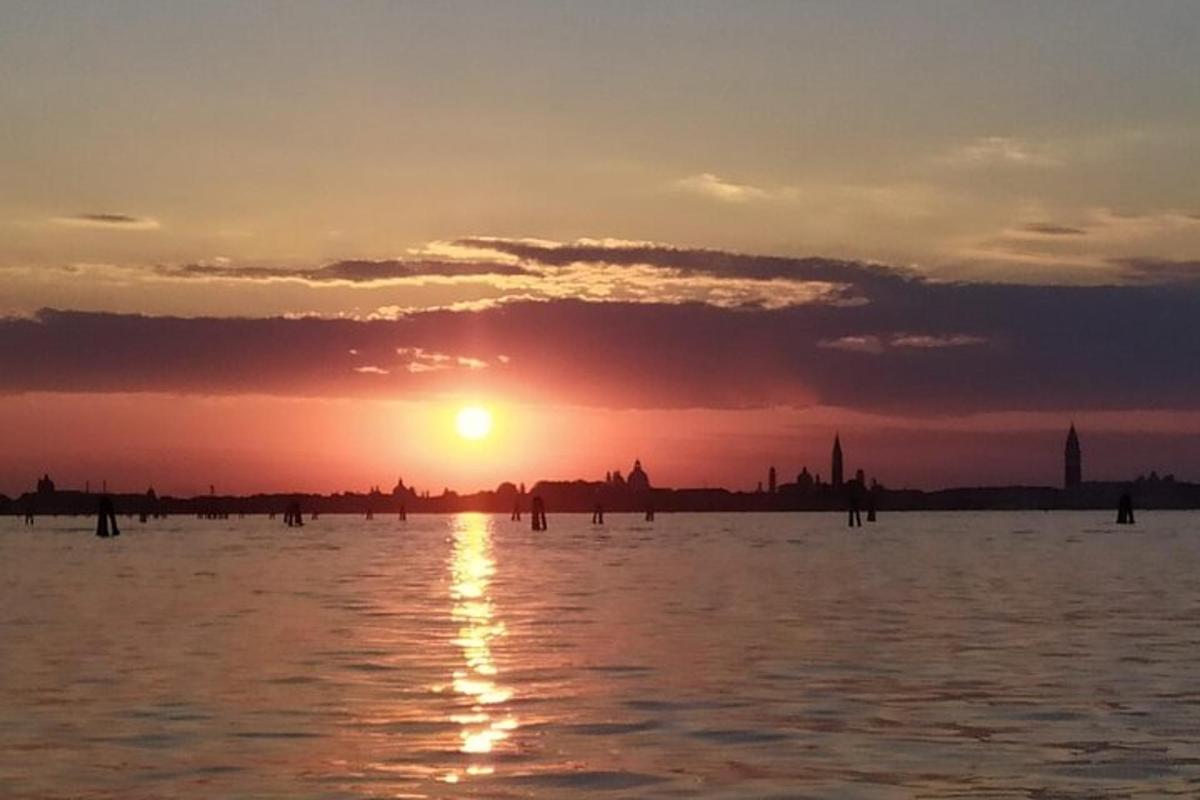 un tramonto su uno specchio d'acqua con il sole che tramonta