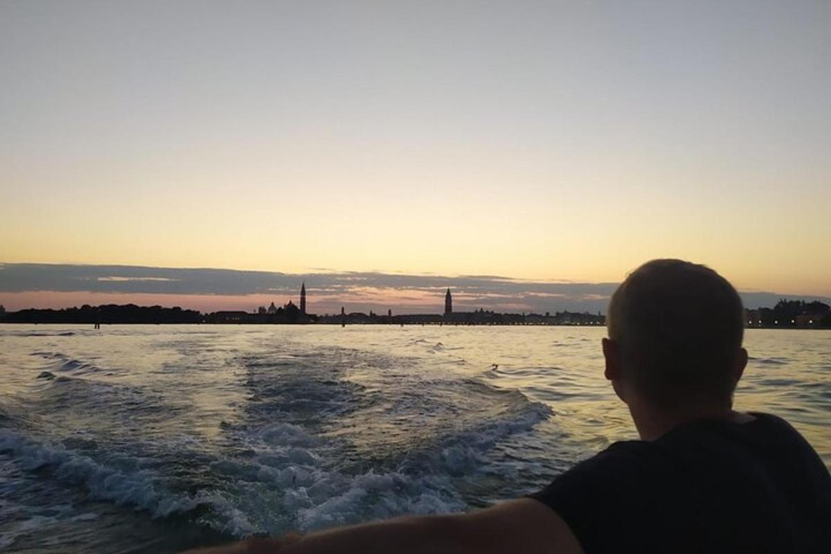 un uomo in barca in acqua al tramonto