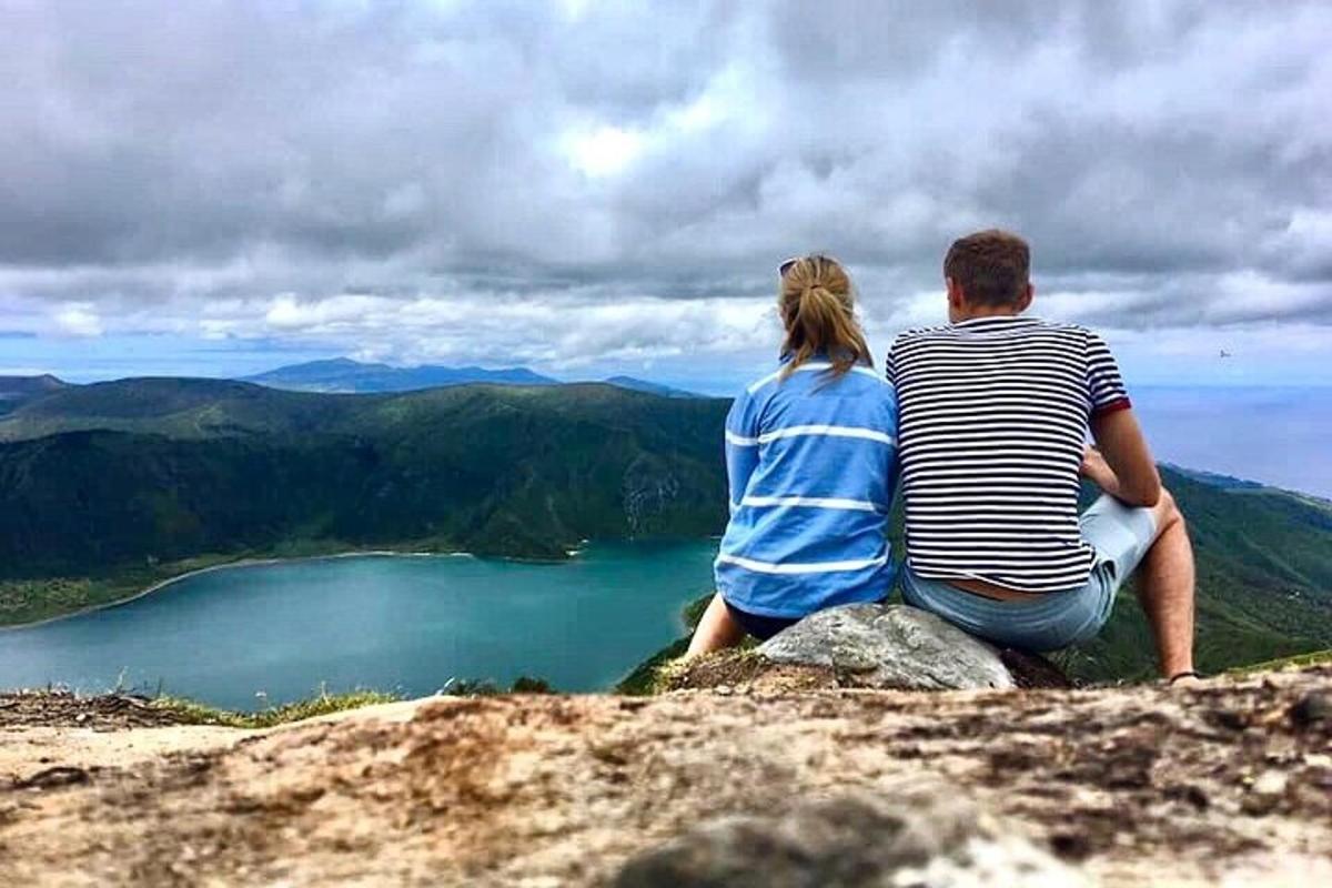et par som sitter på toppen av et fjell med utsikt over en innsjø