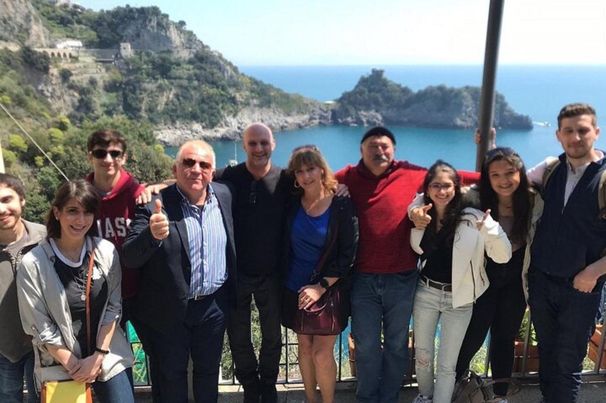eine Gruppe von Menschen posiert für ein Foto vor dem Meer
