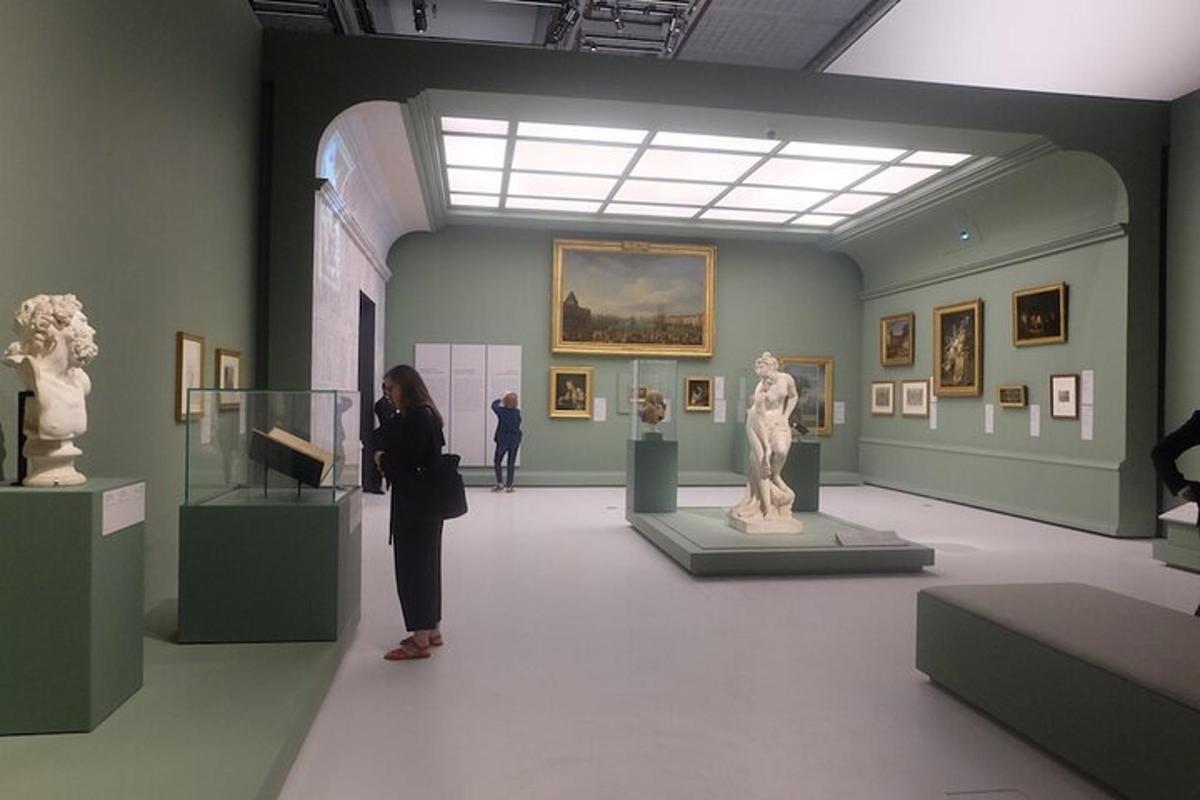 a woman standing in an art museum looking at statues