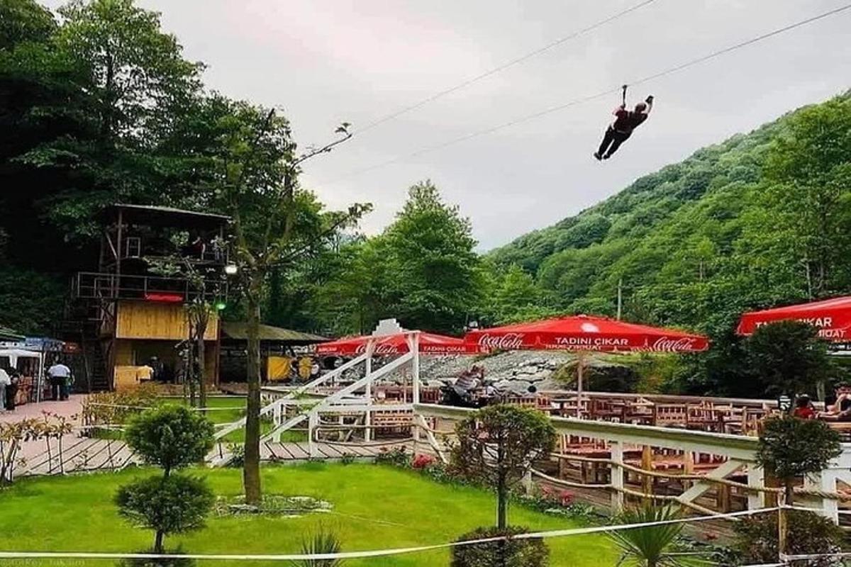 eine Person hängt an einer Seilrutsche in der Luft