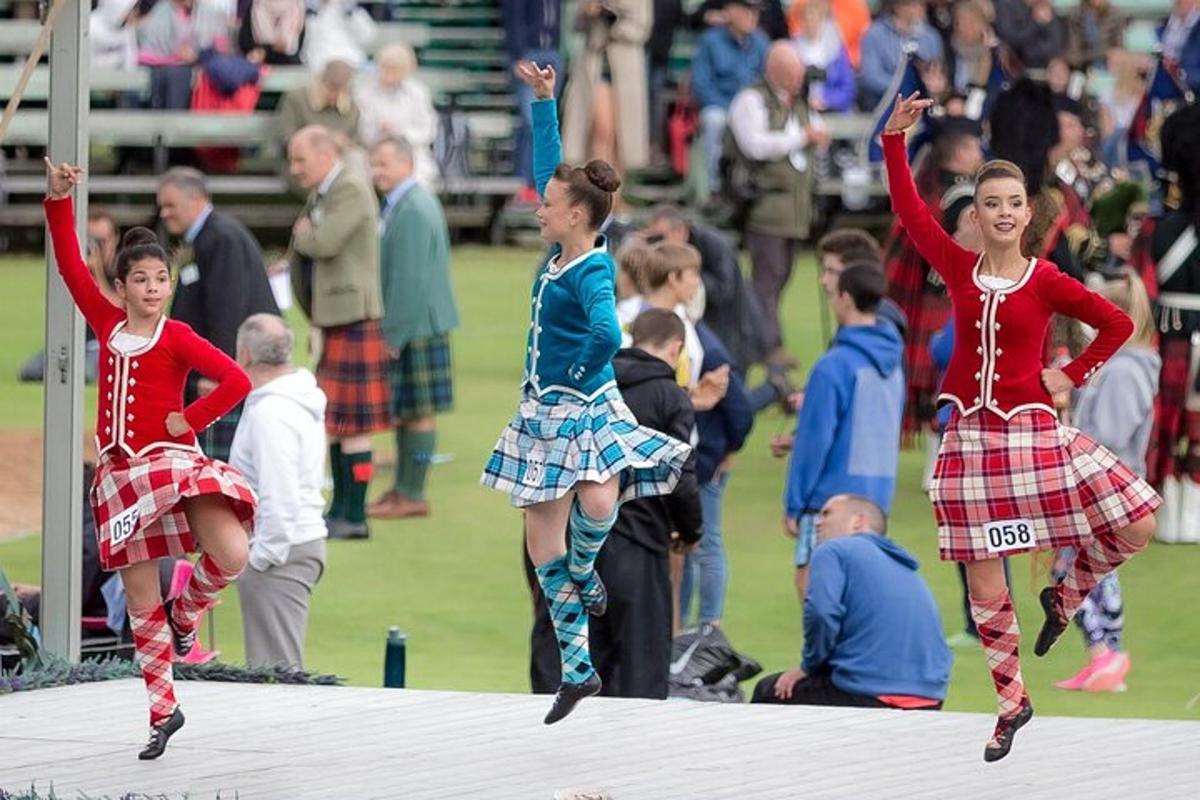 tre ragazze in kilt tartan si esibiscono su un palco