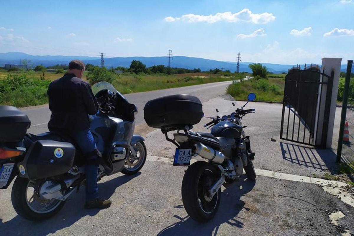 muž sedící na motorce na kraji silnice