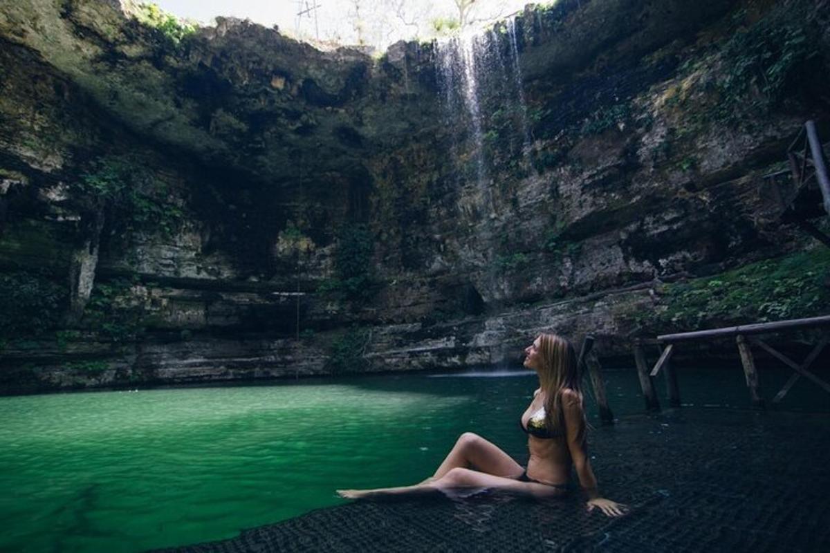 eine Frau, die im Wasser in der Nähe eines Wasserfalls sitzt