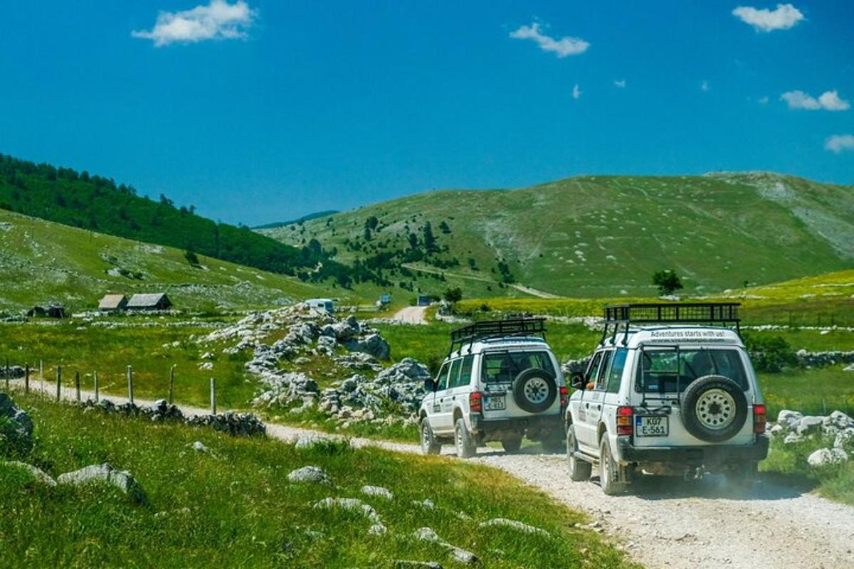 Dos coches estacionados en un camino de tierra en una colina