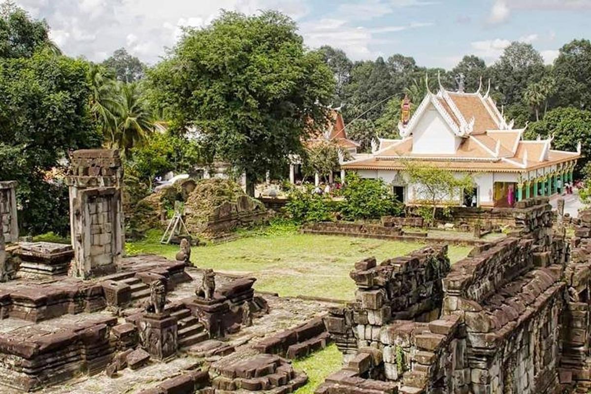 Una vista de un templo con un edificio al fondo.
