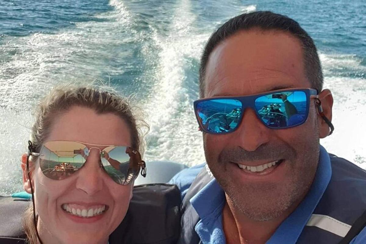 um homem e uma mulher usando óculos de sol em um barco