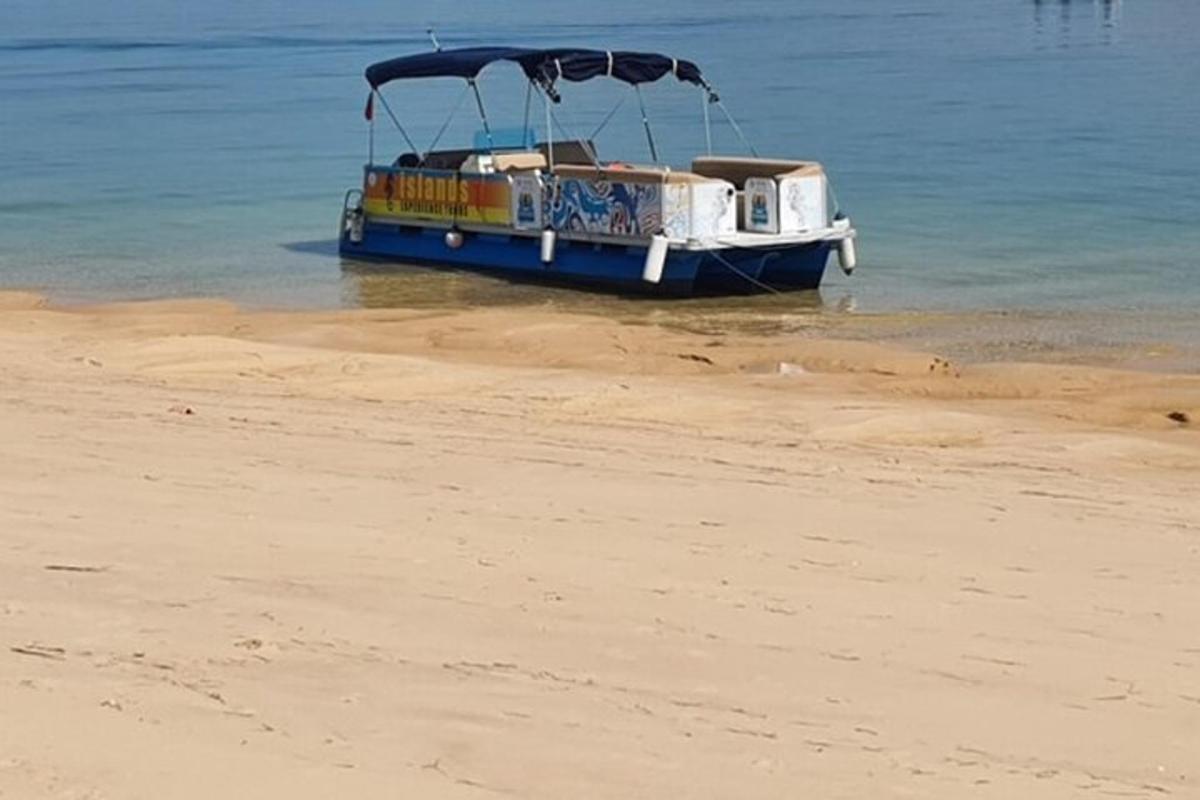 o barcă stând în apă pe plajă