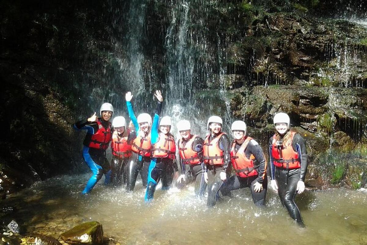 un gruppo di persone in acqua davanti a una cascata