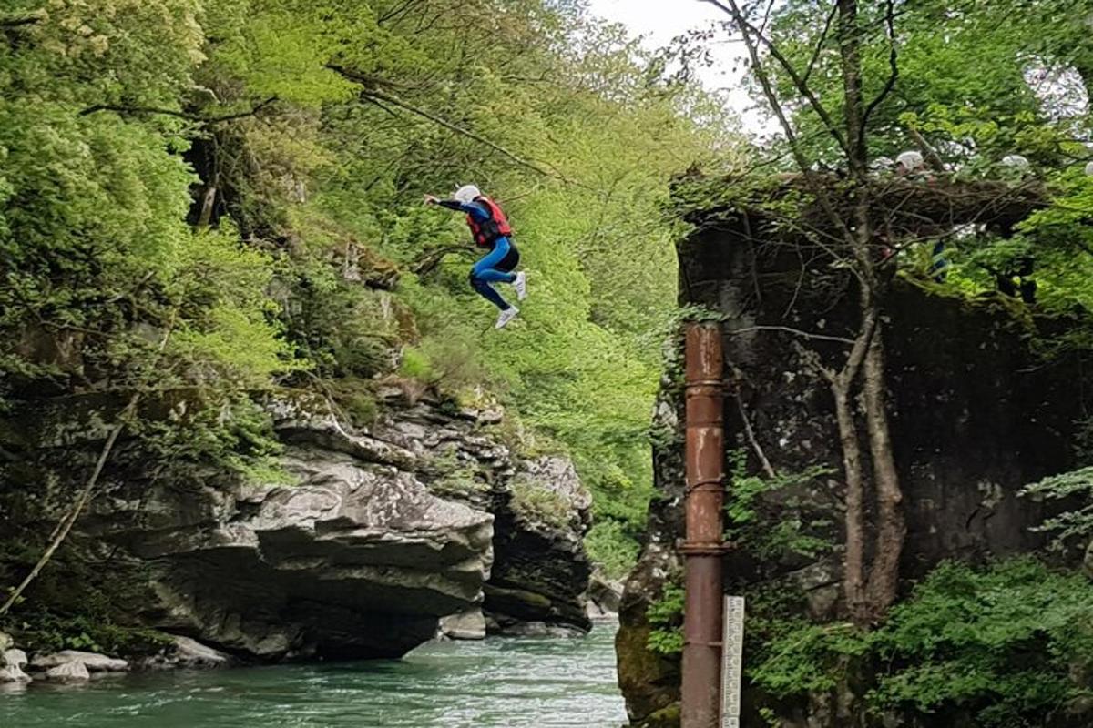 un uomo che salta in aria sopra un fiume