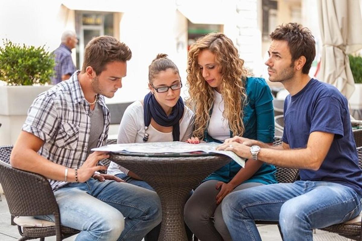 quatro pessoas sentadas ao redor de uma mesa olhando para um mapa