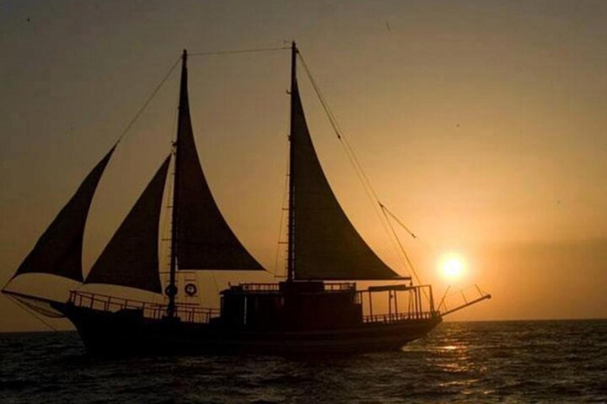 una barca a vela nell'oceano al tramonto