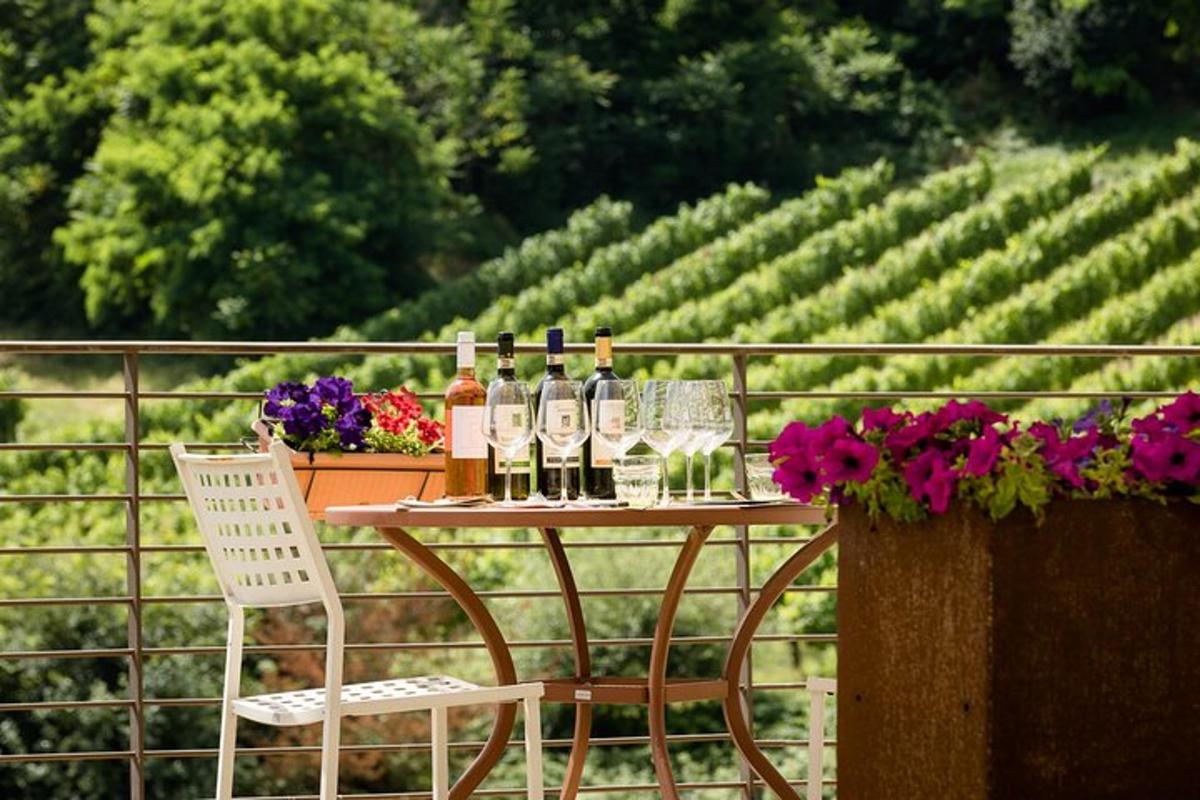 un tavolo con bottiglie, bicchieri da vino e fiori