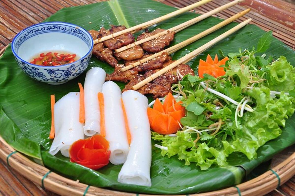 Un plato de comida con carne y verduras en una hoja de plátano.