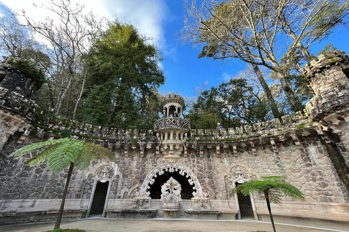 an old stone building with a gate and trees