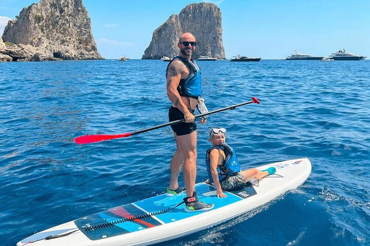 Dva muži stojí na paddleboardu ve vodě