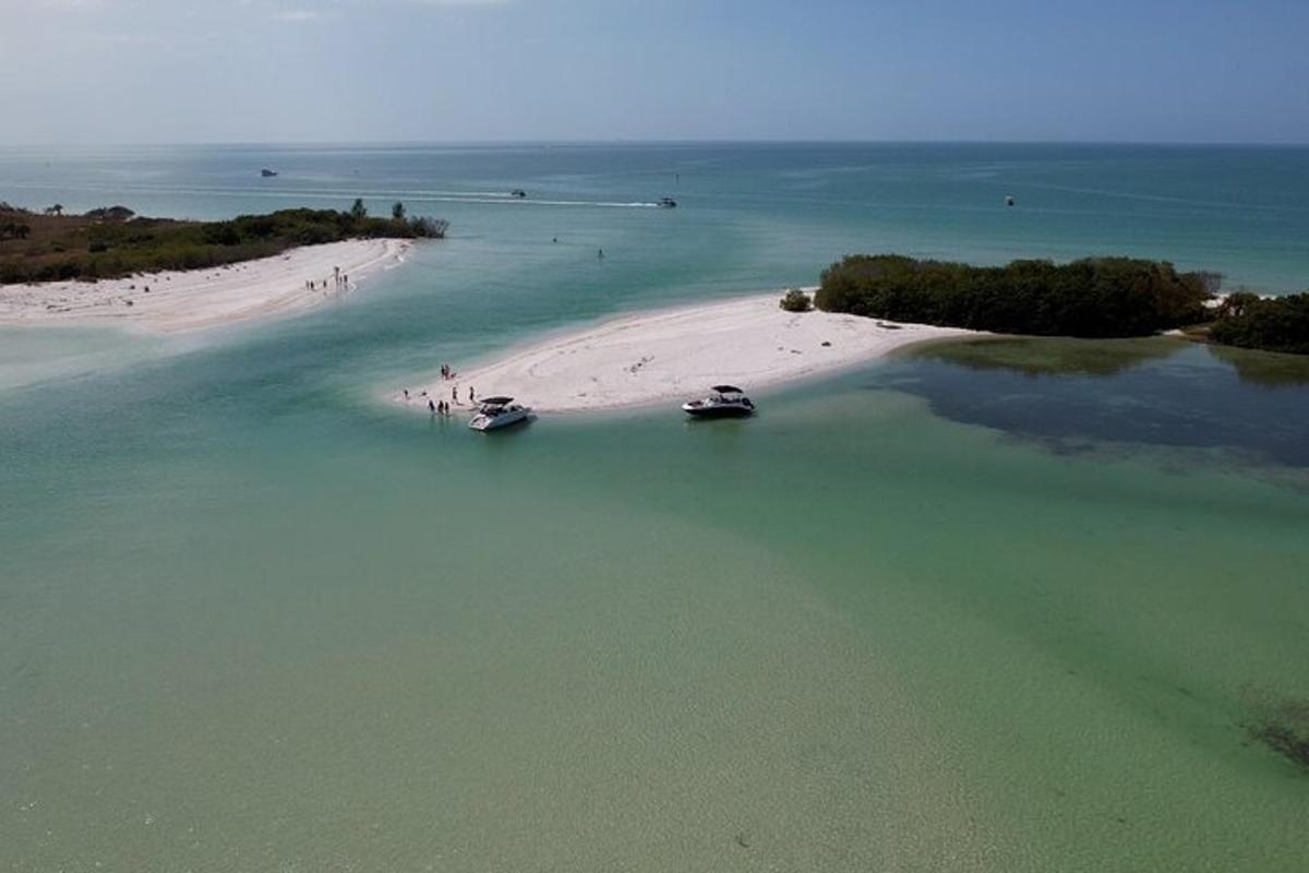 Una vista aérea de una playa con dos barcos en el agua.