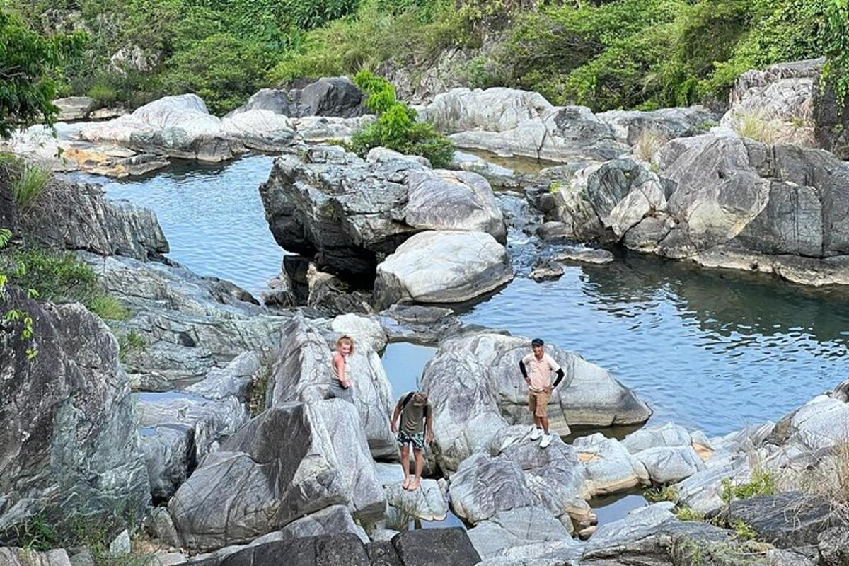 강에 있는 바위 위에 서 있는 사람들의 무리