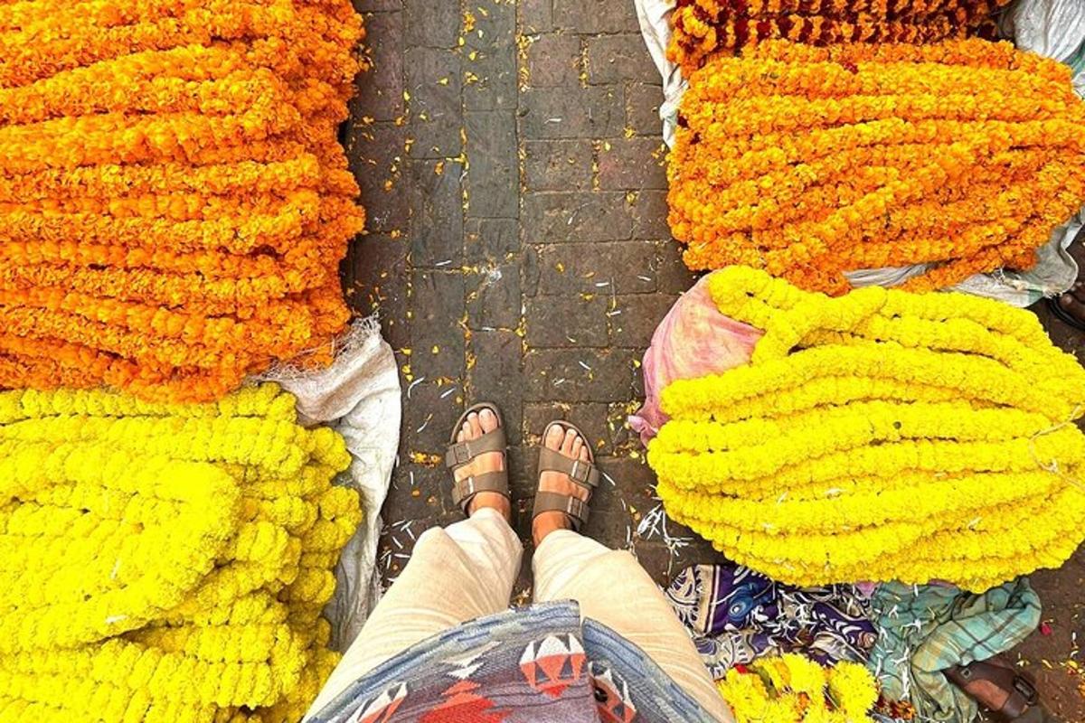 a person standing in front of a pile of flowers