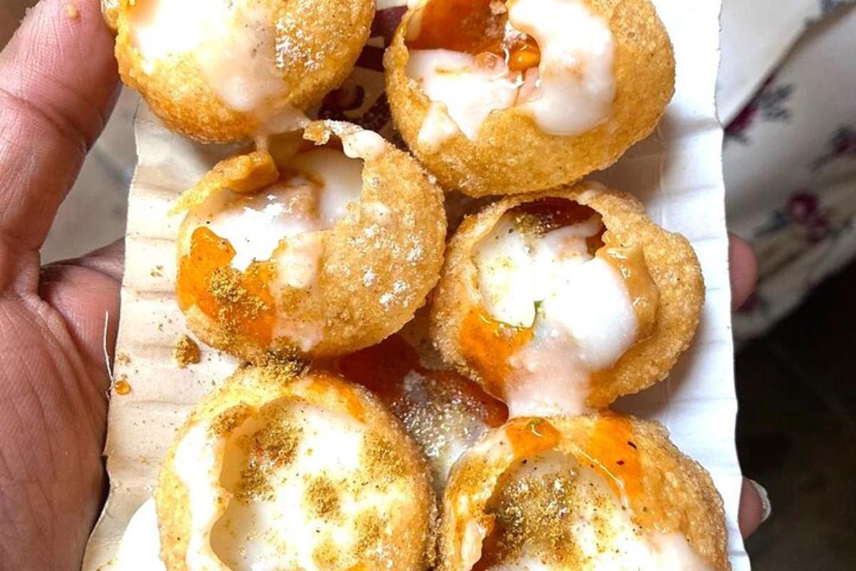 una mano che tiene una pila di ciambelle con glassa