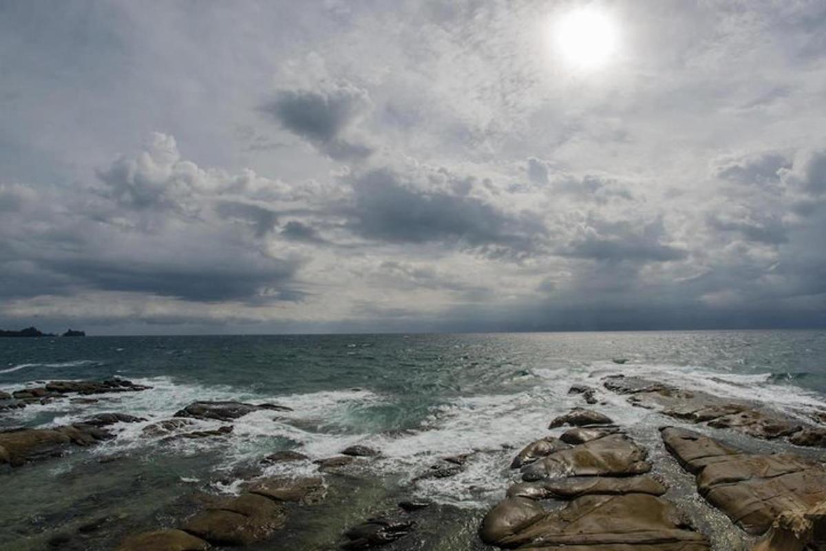 pogled na ocean z valovi, ki se razbijajo ob skale