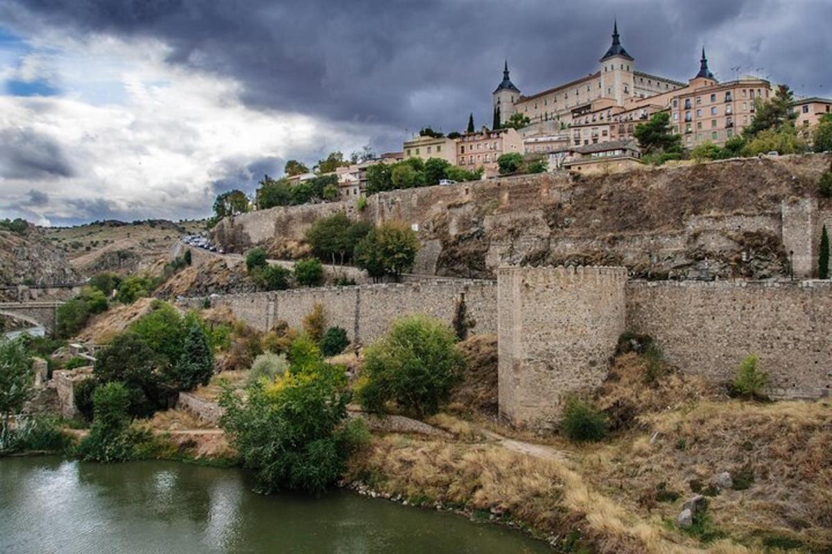 un grande edificio in cima a una collina vicino a un fiume
