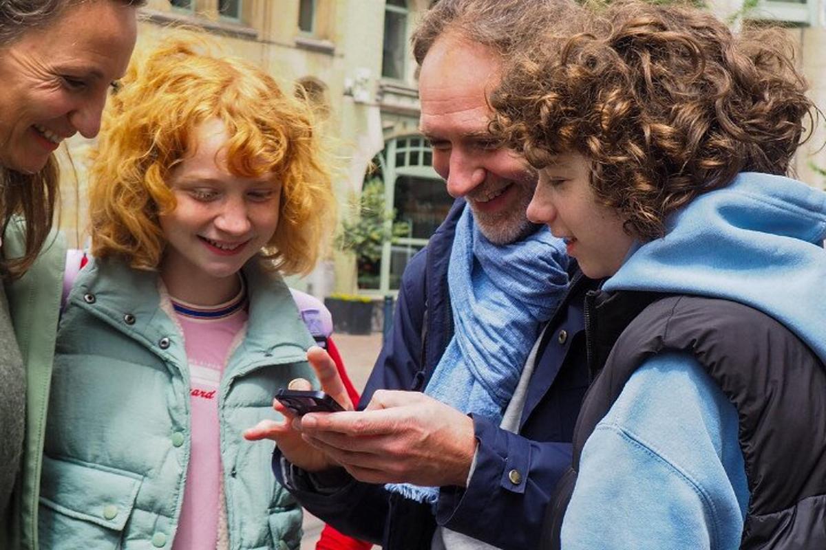 skupina lidí dívajících se na mobilní telefon