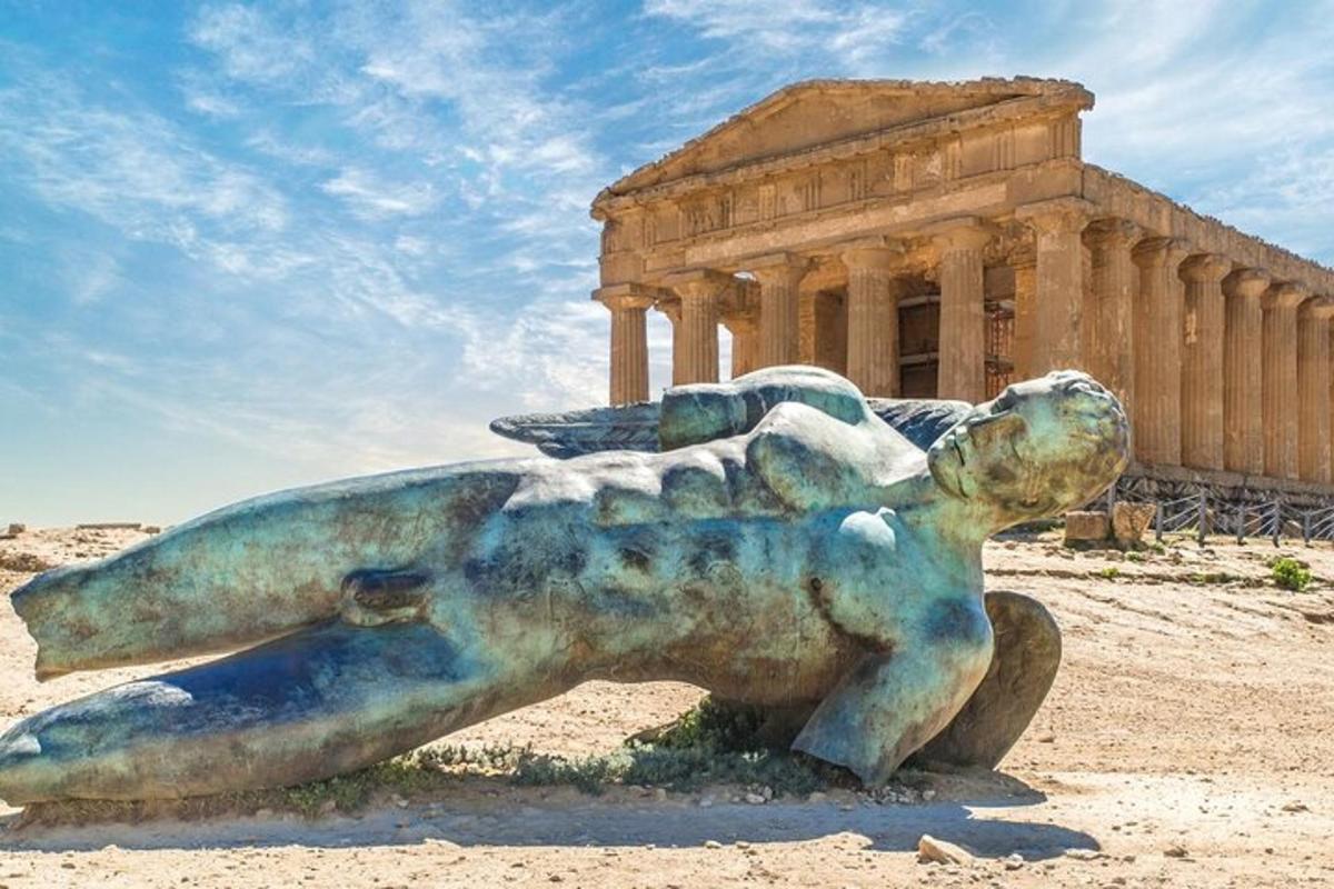 uma estátua de uma mulher deitada em uma rocha em frente a um prédio