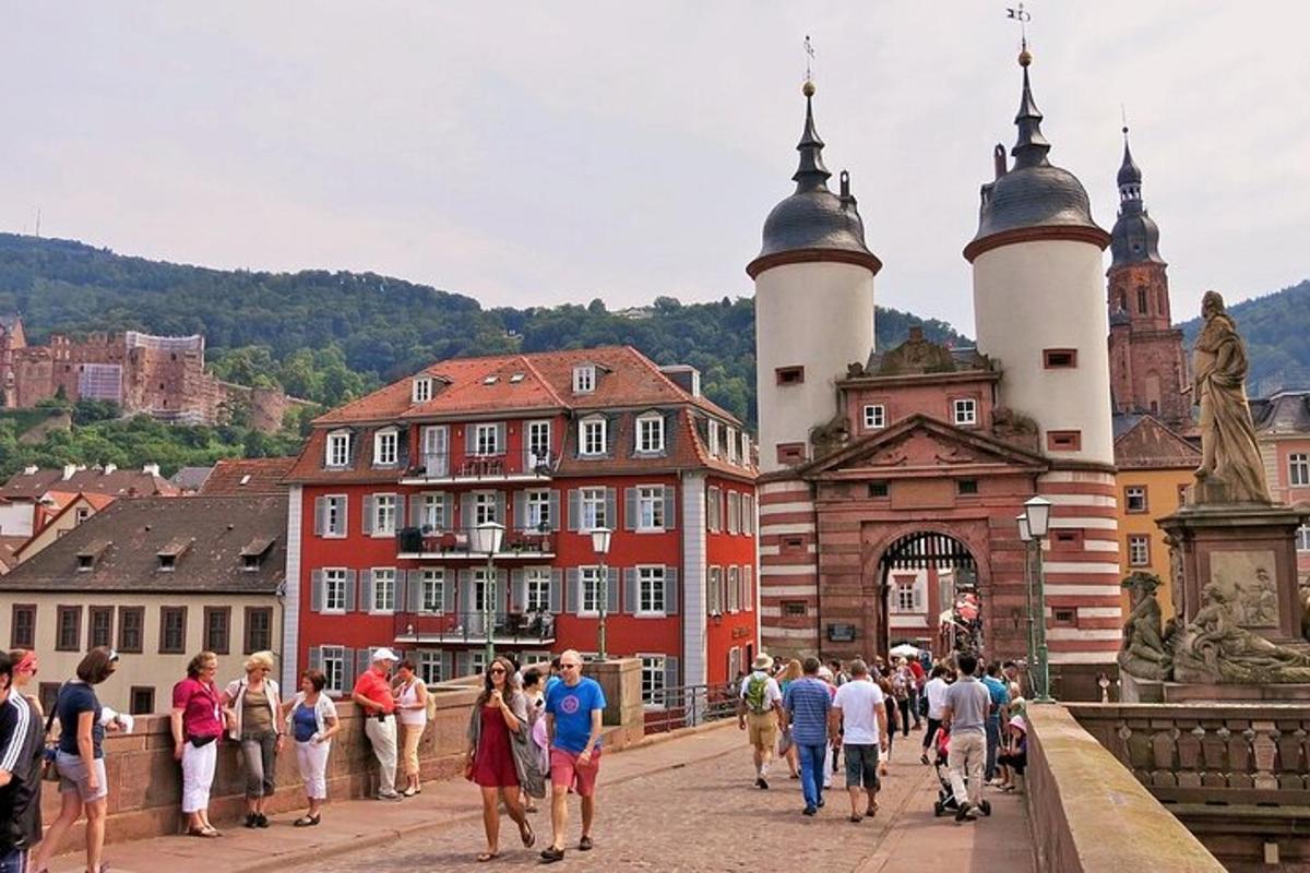 skupina lidí jdoucích přes most před budovami
