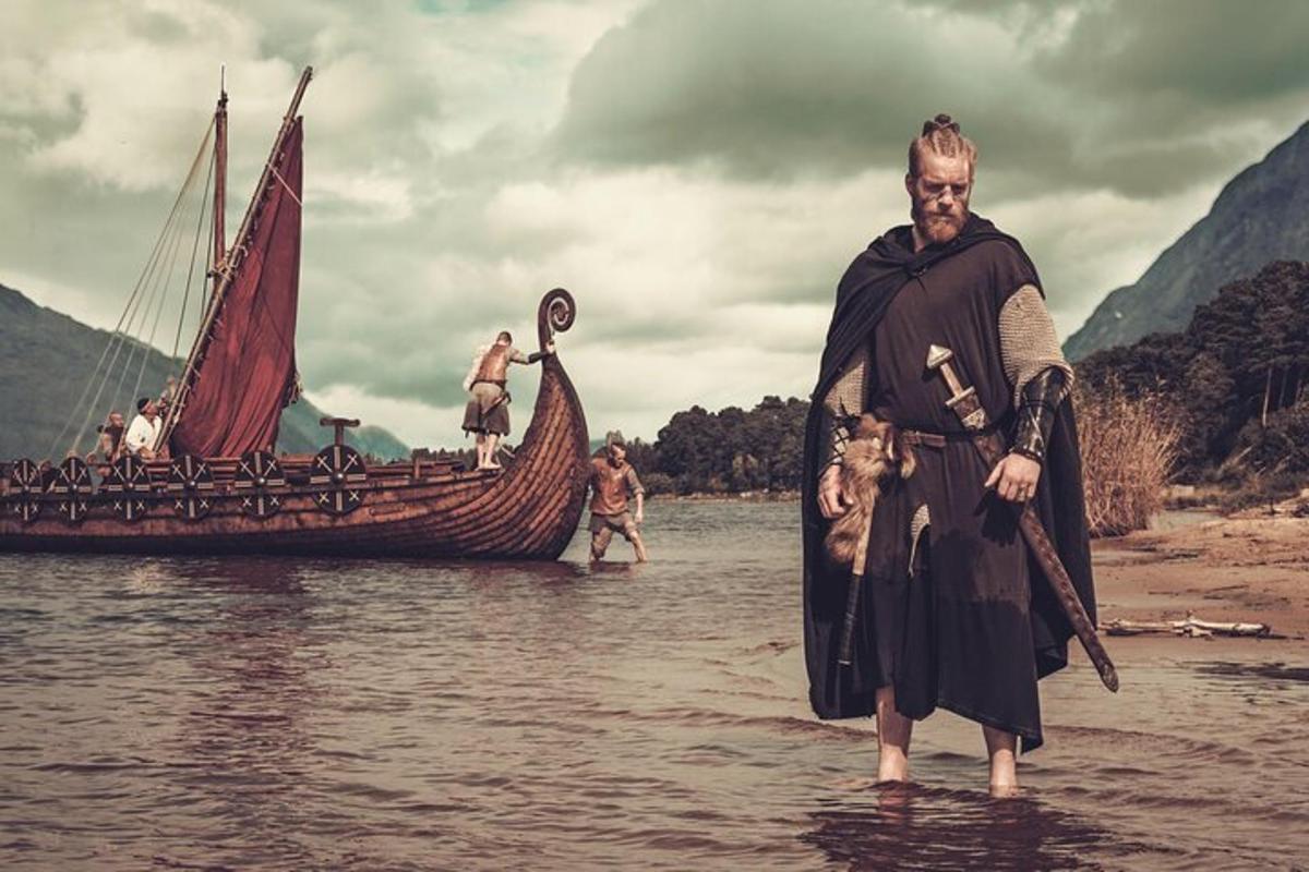 maður stendur í vatninu fyrir framan bát