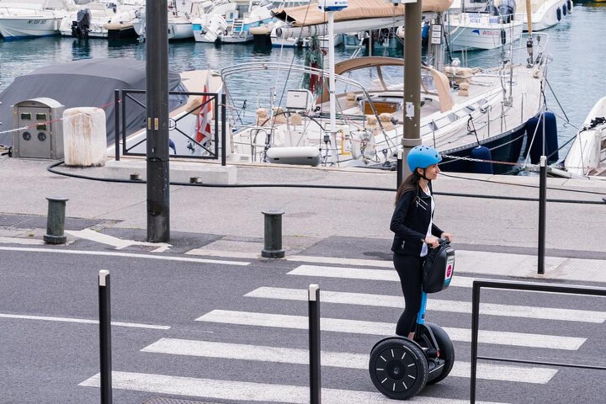 en kvinne som kjører en scooter i en havn med båter
