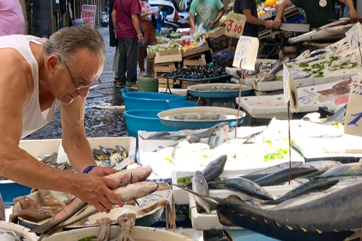 a man looking at a display of fish at a market