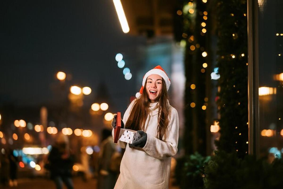 žena v čepici Santy držící mobilní telefon