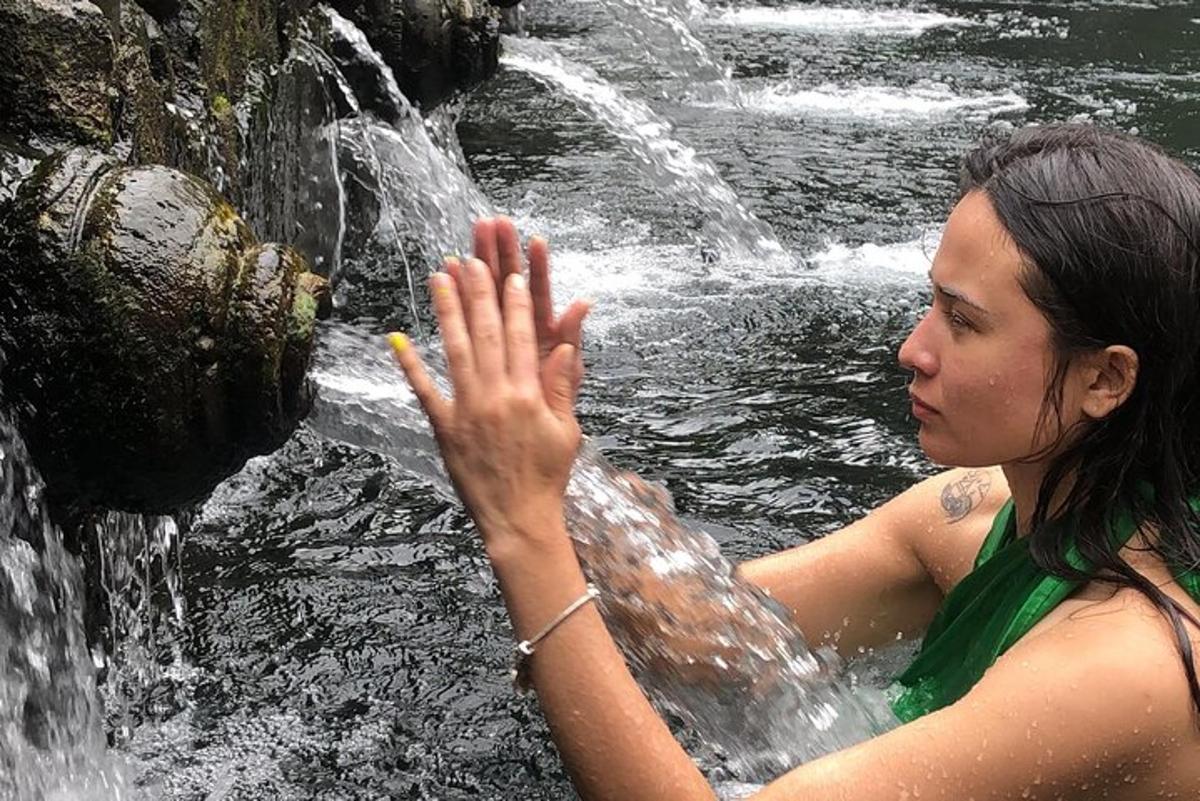 une femme debout dans l'eau près d'une cascade