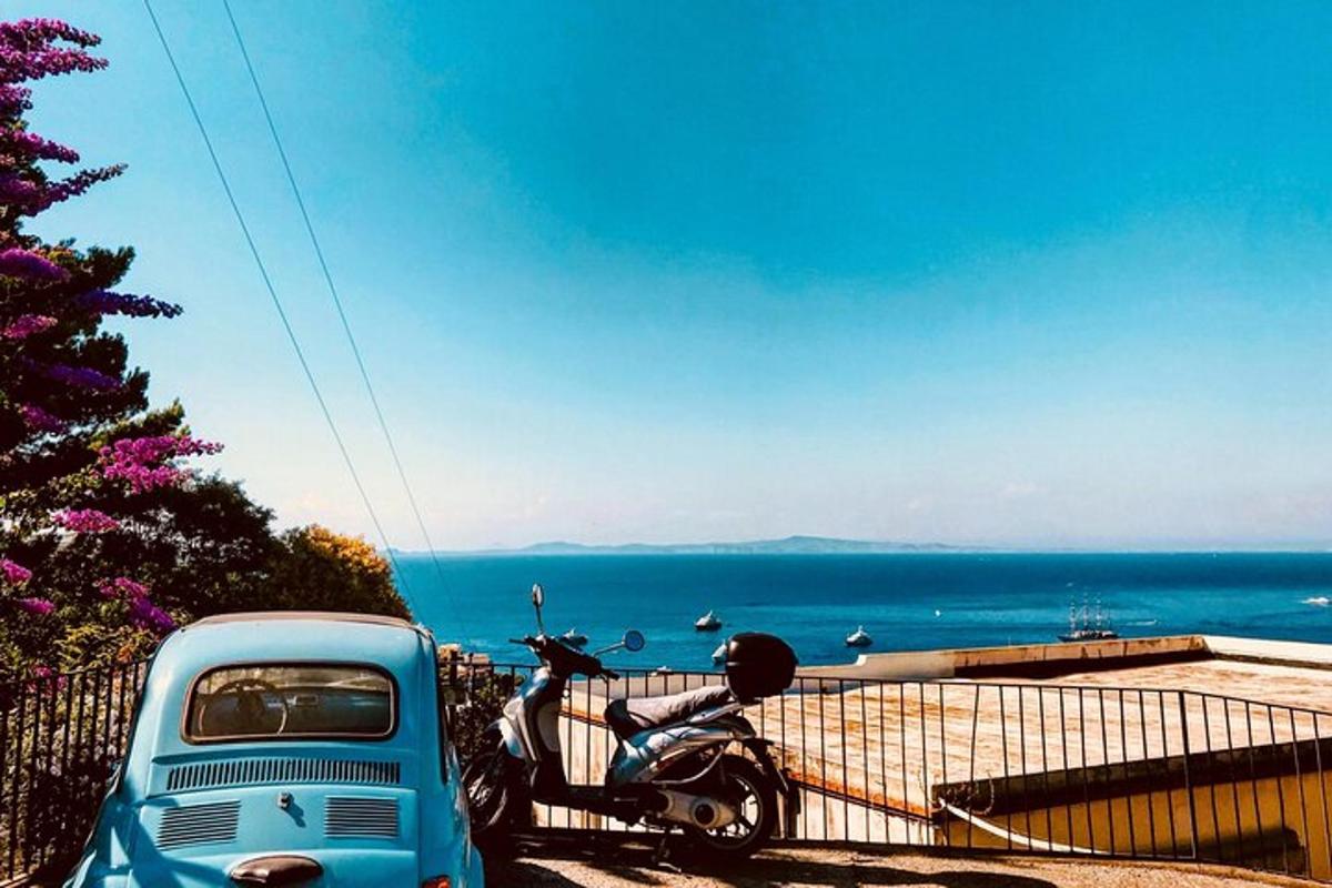 un camion blu e una moto parcheggiati vicino all'oceano