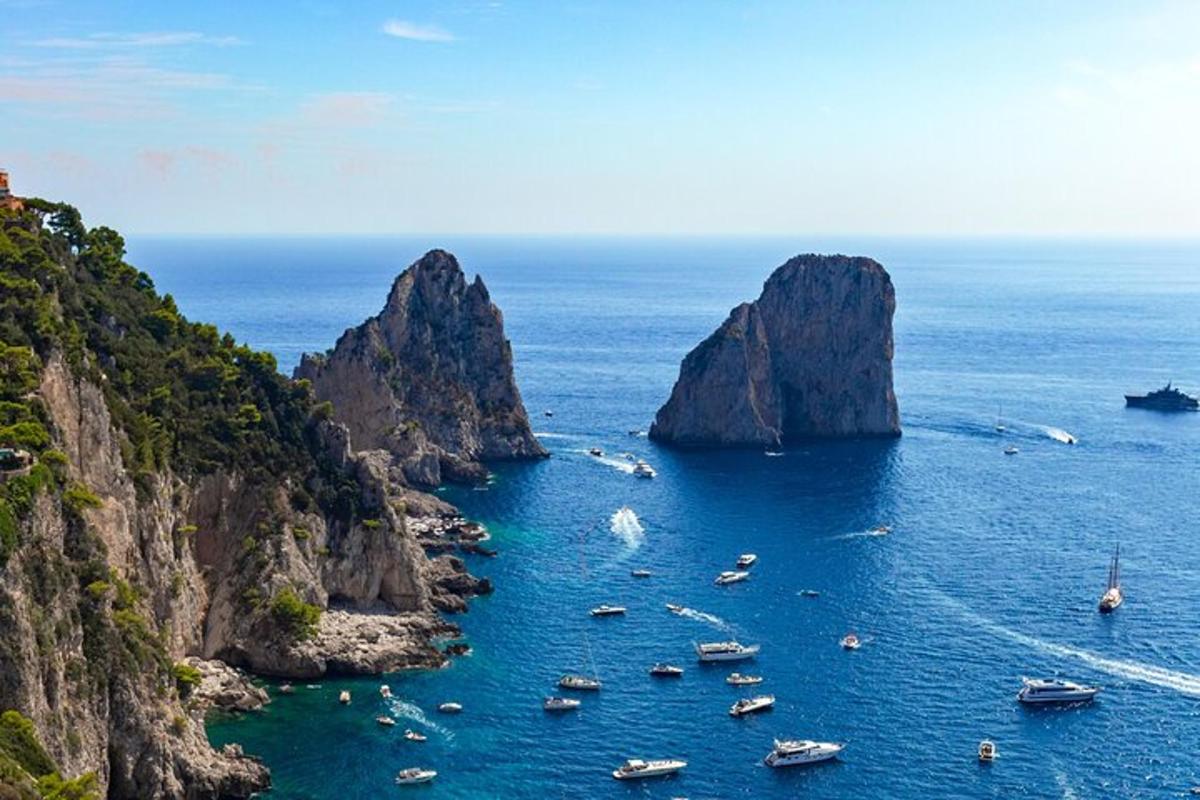 un gruppo di barche nell'oceano con scogliere