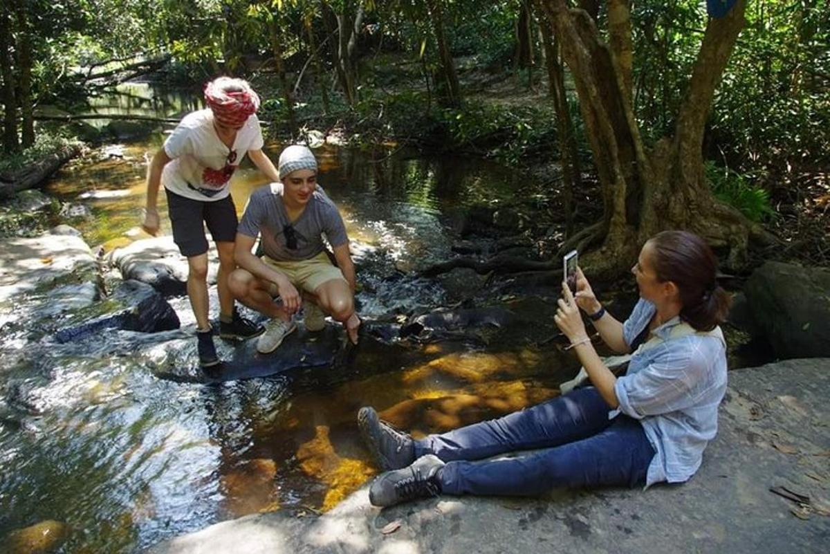 Un grupo de personas sentadas en las rocas de un arroyo.