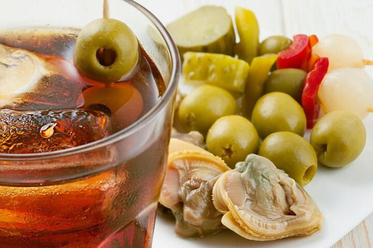 Un vaso de líquido al lado de un grupo de frutas.