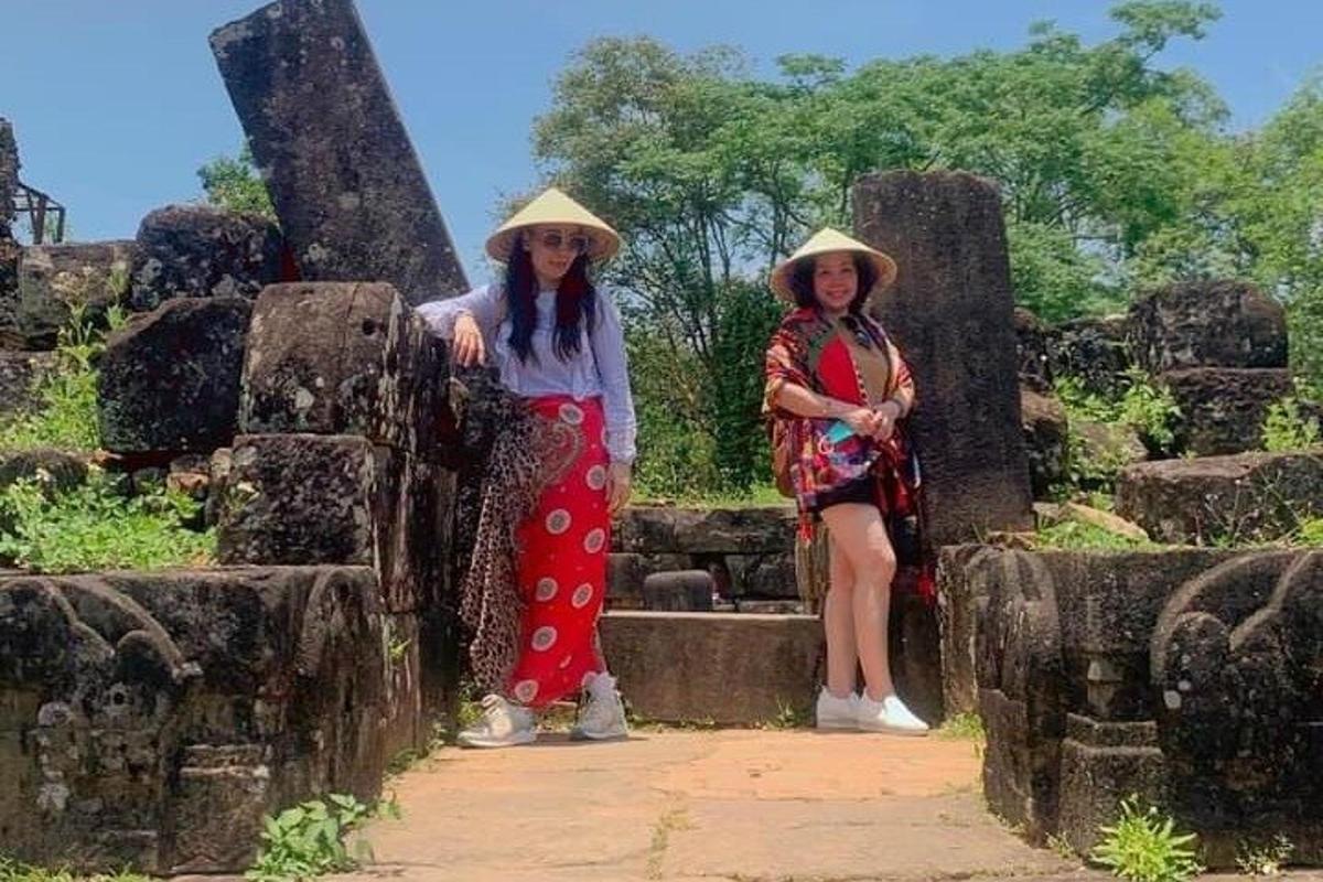 two women wearing hats standing next to some ruins