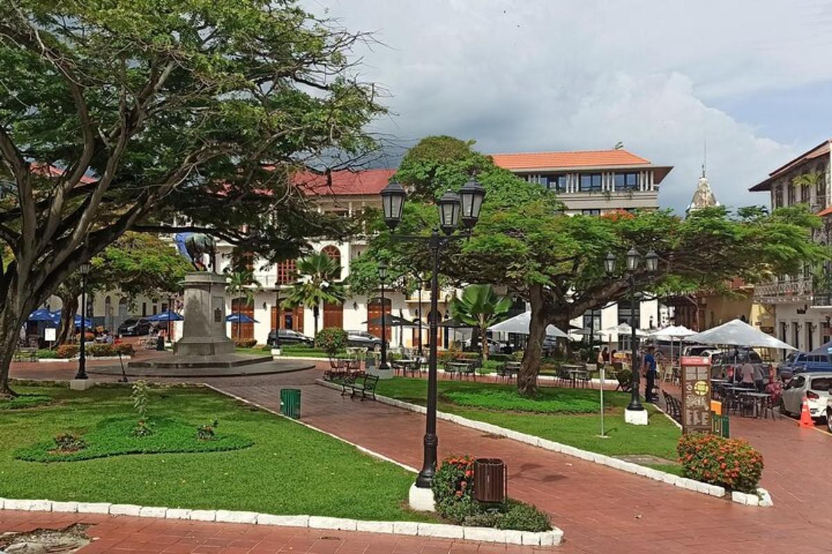 egy park szökőkúttal, fákkal és egy épülettel