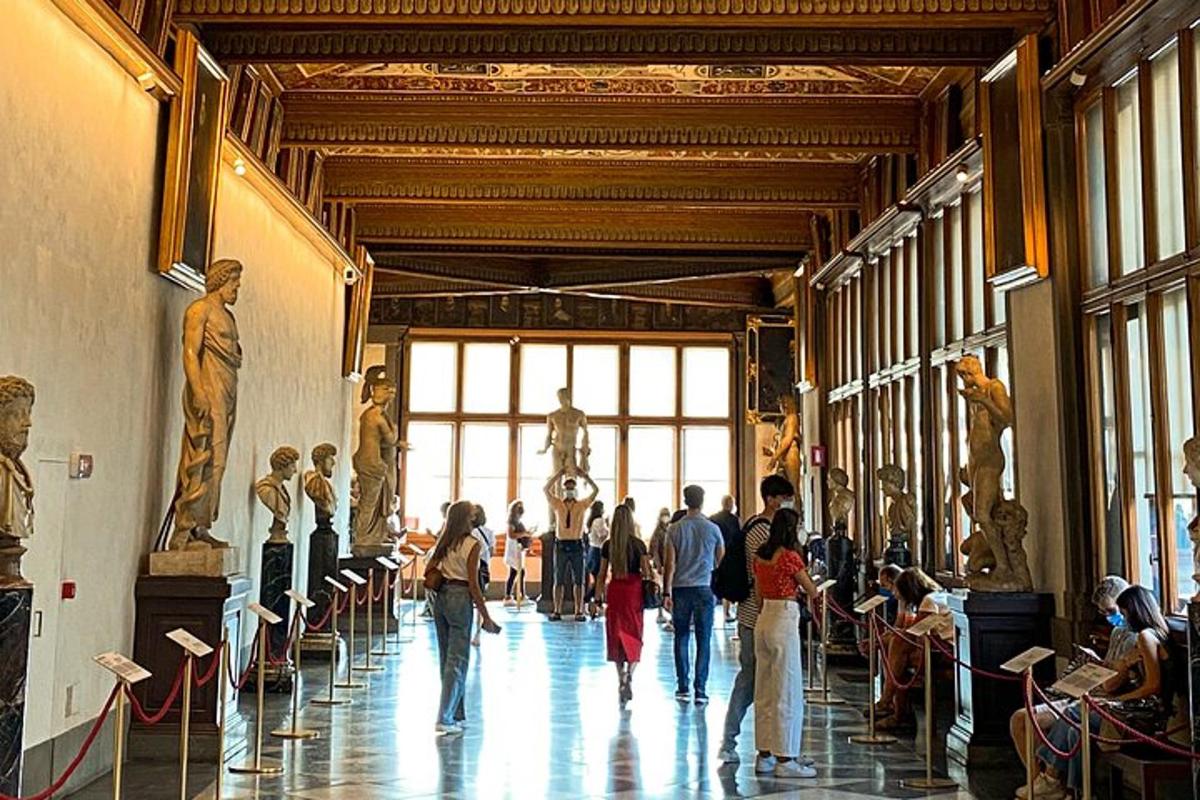um grupo de pessoas caminhando por um museu com estátuas