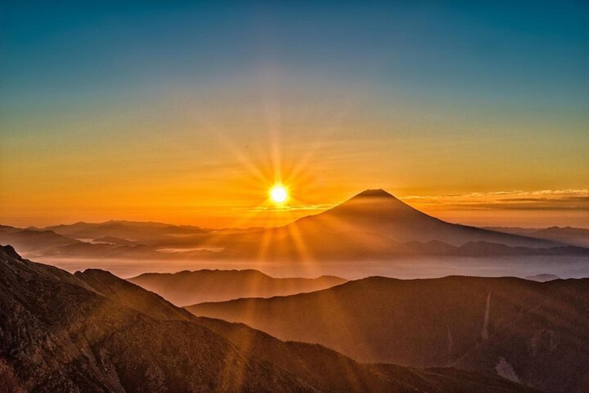 Una vista de una montaña con la puesta de sol sobre ella.